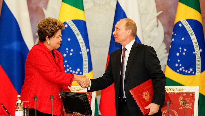 La Rousseff stringe la mano al presidente russo Vladimir Putin, grande alleato internazionale del Brasile. I due Paesi hanno nel luglio scorso siglato un accordo (insieme a Cina, India e Sudafrica) che prevede la nascita di un sistema monetario alternativo al dollaro.