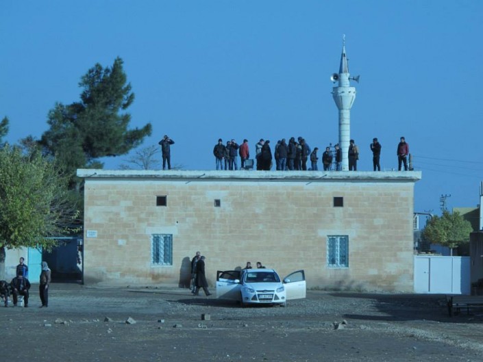  Abitanti di Mehser guardano i combattimenti dal tetto della moschea